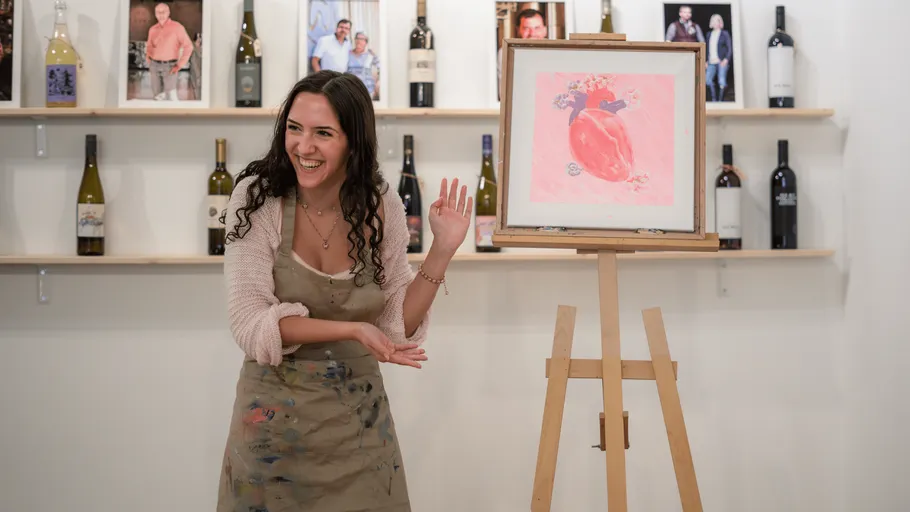 Woman painting, smiling, in art studio.