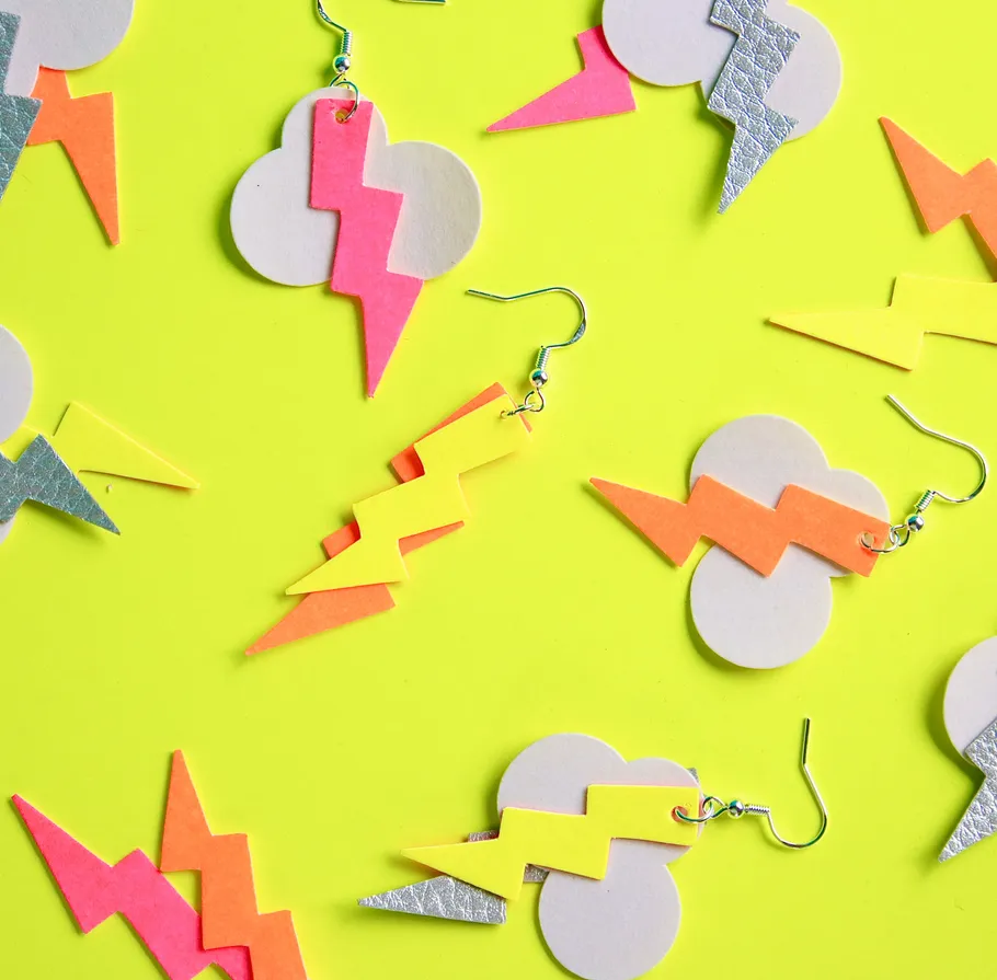Colorful lightning earrings on yellow background.