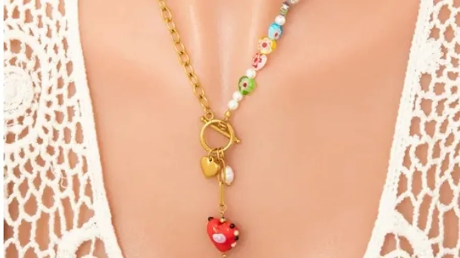Colorful necklace with heart pendant on mannequin.