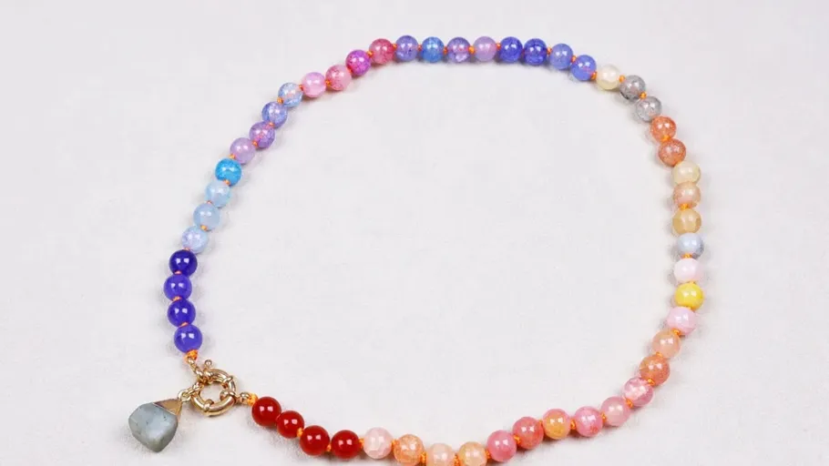 Multicolored bead necklace on white surface.
