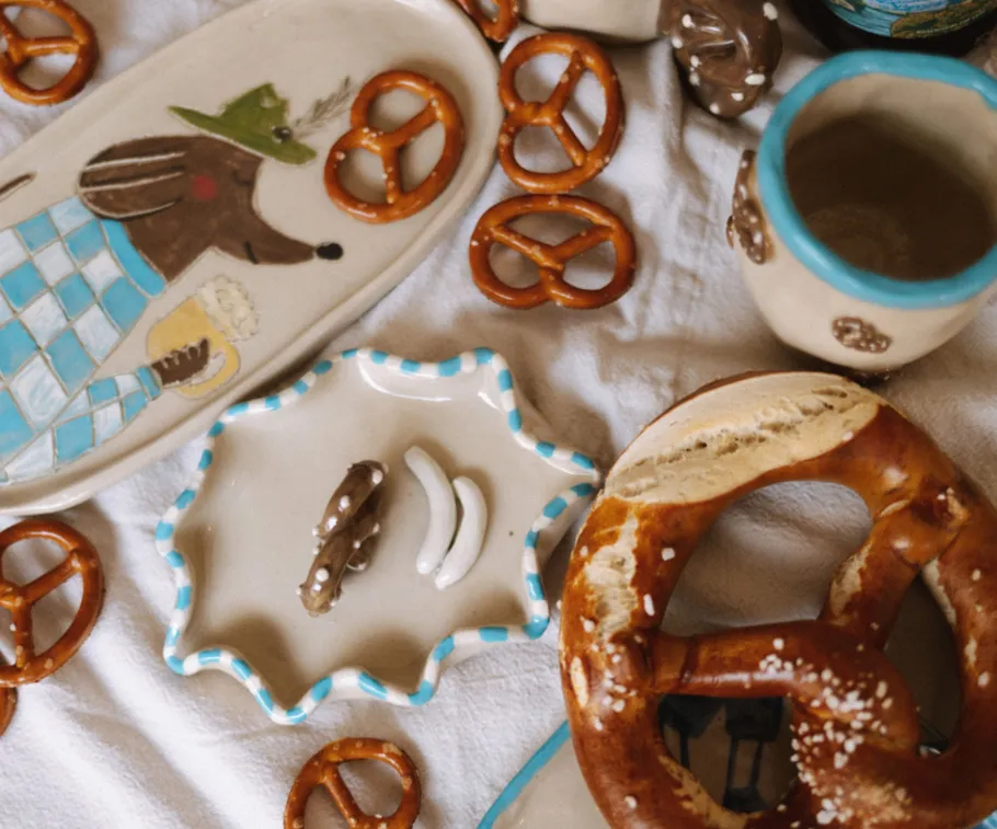 Ceramic dishes with pretzels on white cloth.