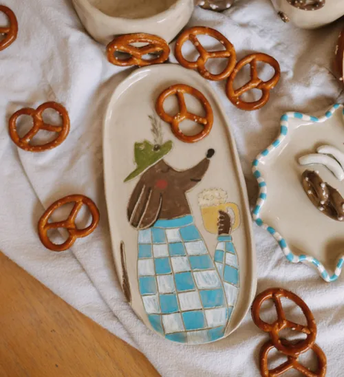Ceramic oval platter with dog design and pretzels.