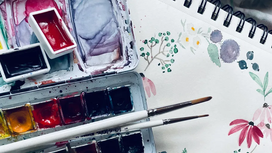 Pinsel und Aquarellfarben auf Skizzenbuch.