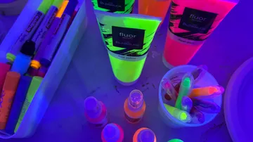 Fluoreszierende Farben und Marker unter Schwarzlicht.