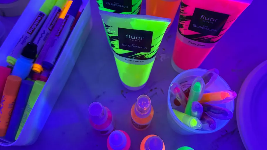 Fluoreszierende Farben und Marker unter Schwarzlicht.