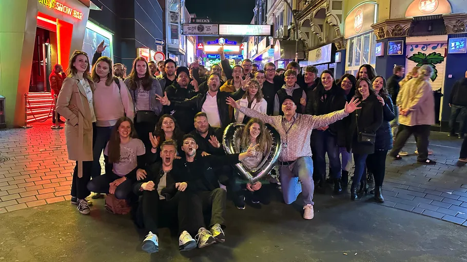 Group celebrating on lively city street at night.