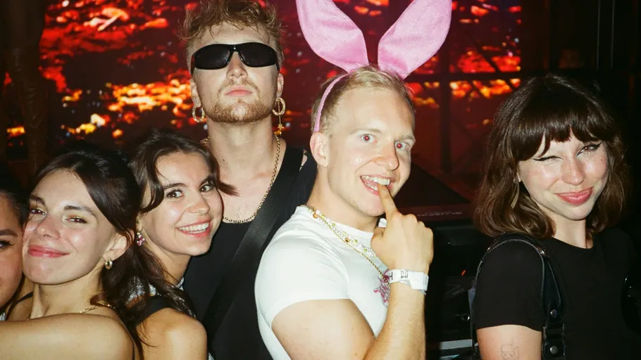 Group of people posing at a nighttime event.