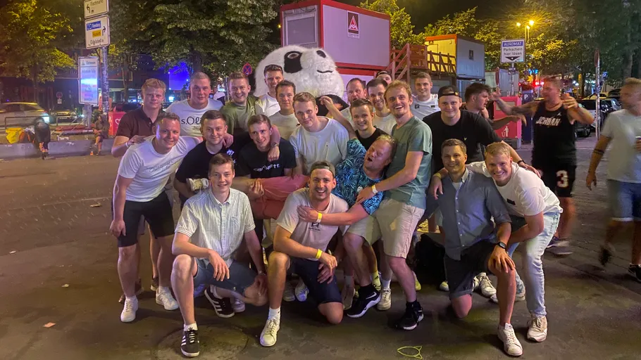 Gruppe von Männern posiert auf einer Stadtstraße.