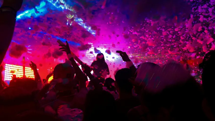 Menge genießt Schaumparty mit bunten Lichtern.