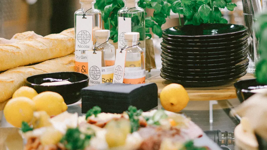 Bottles, baguettes, and lemons on a table.