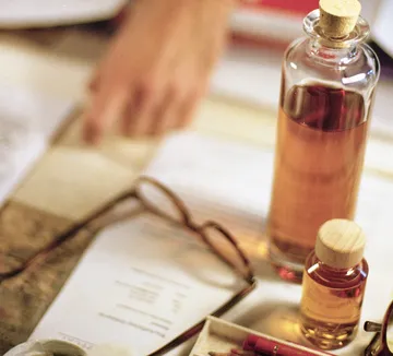 Glass bottles on book near person's hand.