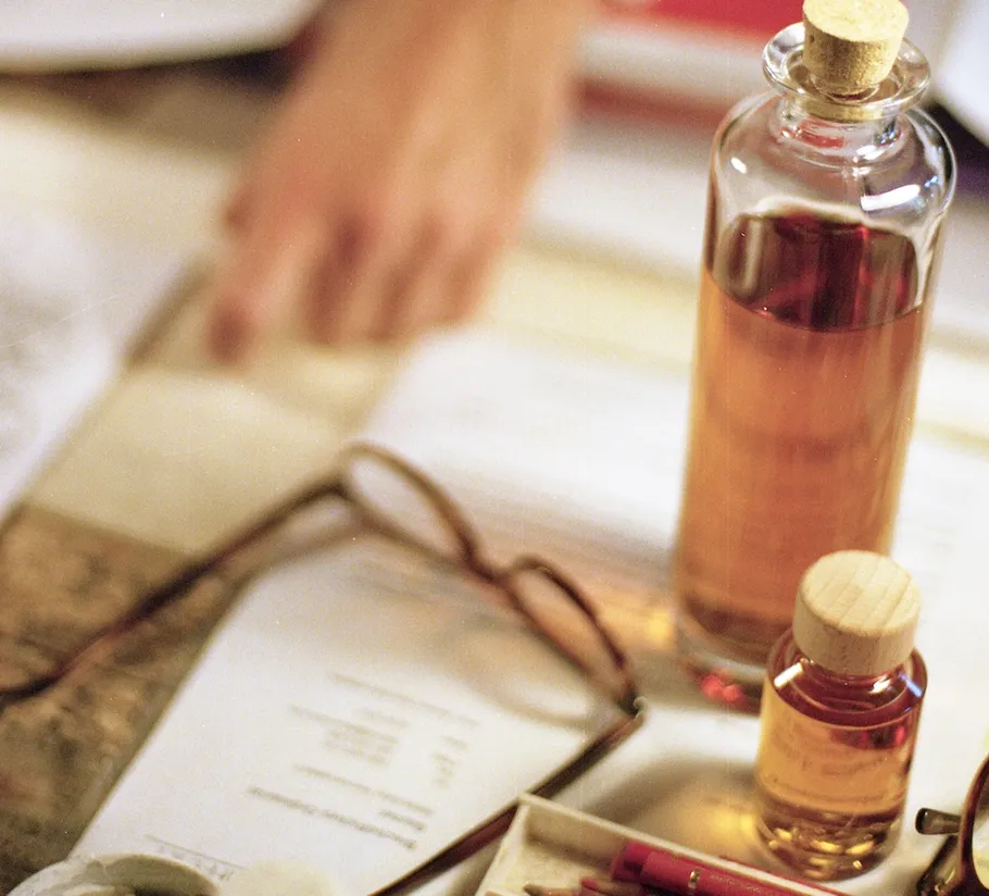 Glass bottles on book near person's hand.