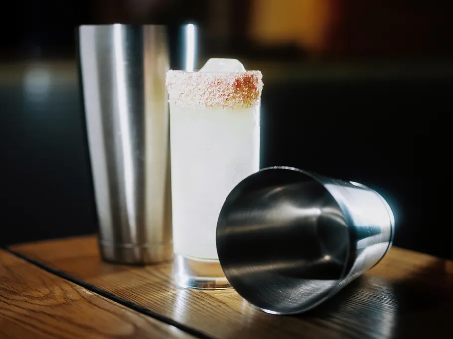 Glas mit Zuckerrand zwischen zwei Metallshakern.