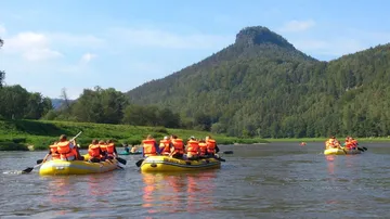 People rafting on a river amid mountains.