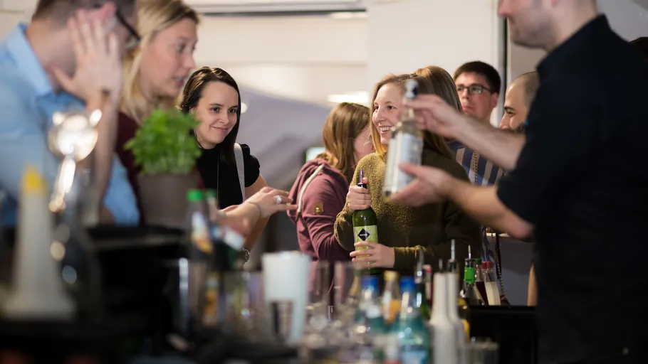 Leute unterhalten sich an einer Bar mit Getränken.