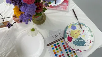 Blumen und Malutensilien auf einem Tisch.