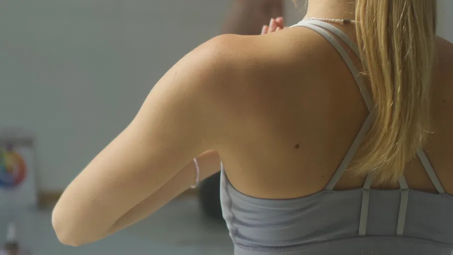 Frau in Yogapose mit unscharfem Hintergrund.