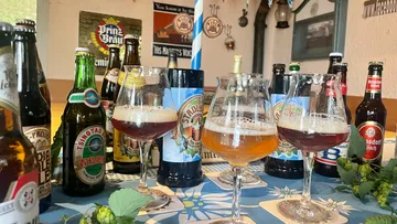 Various beer bottles and glasses on a table.