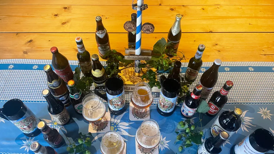 Assorted beer bottles and glasses on table.