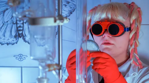 Scientist examines beaker in laboratory with goggles.