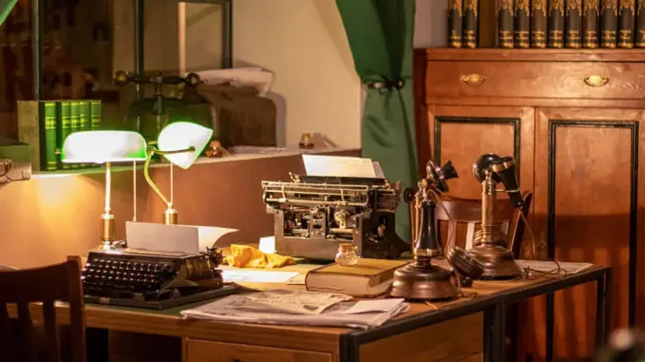 Vintage-Schreibtisch mit Schreibmaschine und Telefonen.