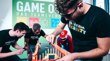Four men playing a tabletop game indoors.