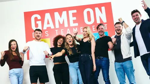 Group of people celebrating in front of sign.
