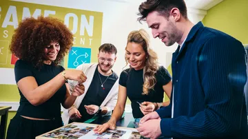 Four people collaborating in a game room.