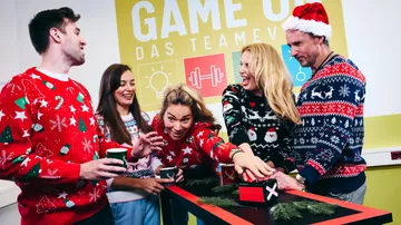 People in Christmas sweaters enjoying team event.