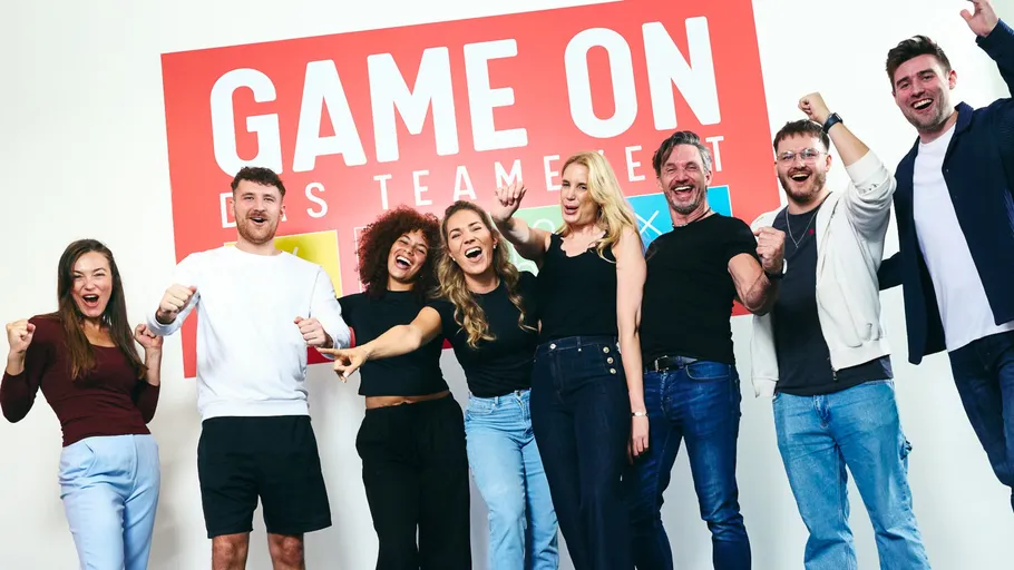 Group of eight people celebrating indoors.