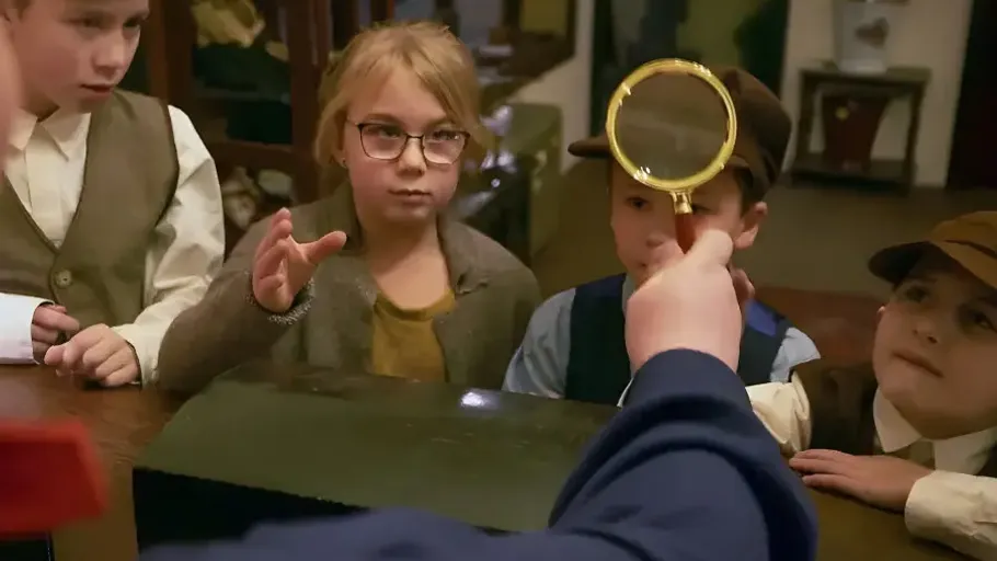 Kinder untersuchen eine Lupe drinnen.