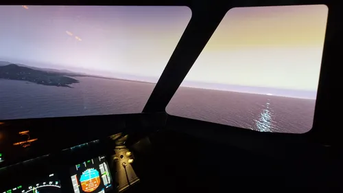 Cockpitansicht, Sonnenuntergang über dem Ozean, Instrumente sichtbar.