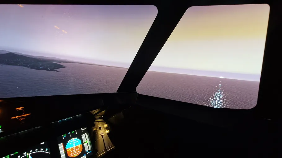 Cockpit view, sunset over ocean, cockpit controls visible.