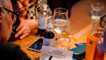 People writing notes at a bar table.