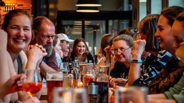 People enjoying drinks at a lively bar.