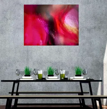 Abstract painting above table with chairs.