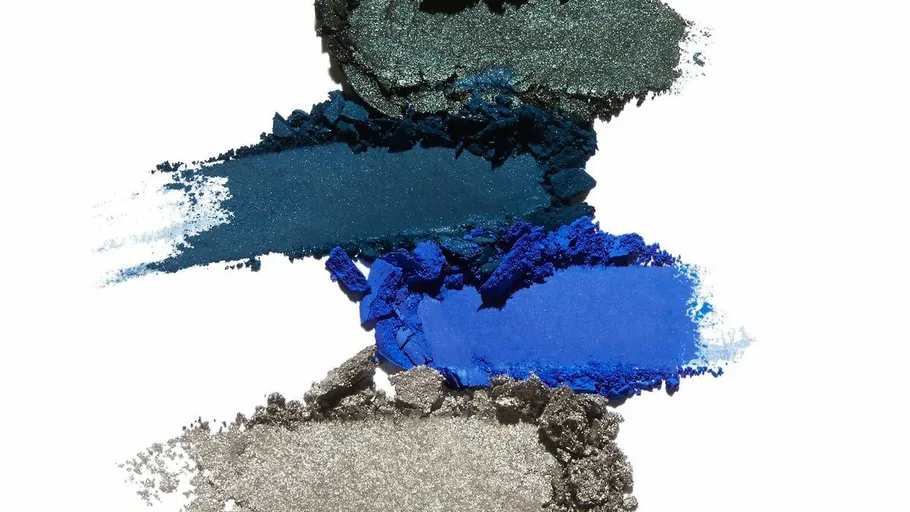 Colorful eyeshadow pigments arranged on white background.