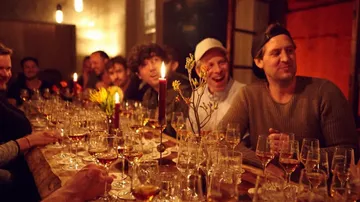 People enjoying drinks in a dimly lit room.