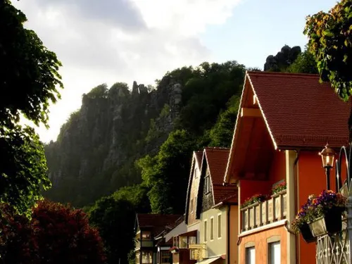 Häuser stehen friedlich vor Bergen im Sonnenlicht.