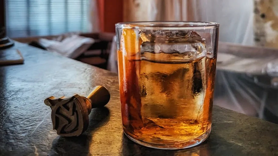 Glass of whiskey and seal on table.