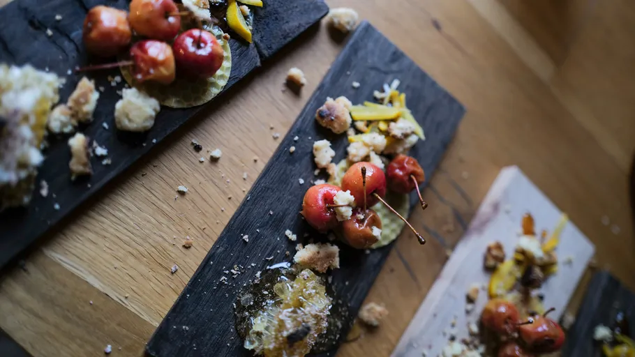 Gourmet-Dessert mit Obst und Krümeln auf Holz.