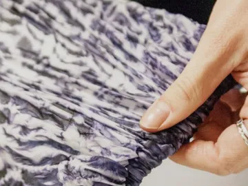 Hand holding a folded, patterned fabric.