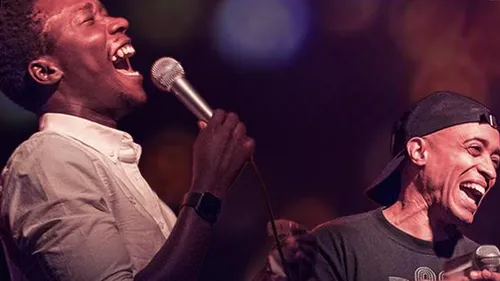 Two comedians performing on stage with microphones.