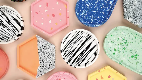 Colorful terrazzo coasters arranged on a beige surface.