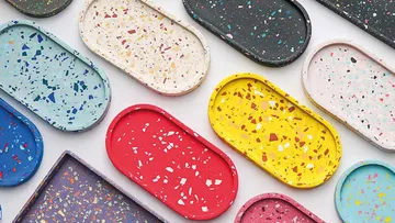 Bunte Terrazzo-Tabletts auf flacher Oberfläche angeordnet.