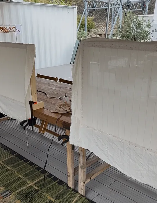 Two fabric screens on a wooden table outdoors.