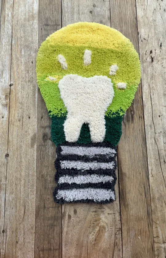 Rug shaped like a tooth on wood floor.