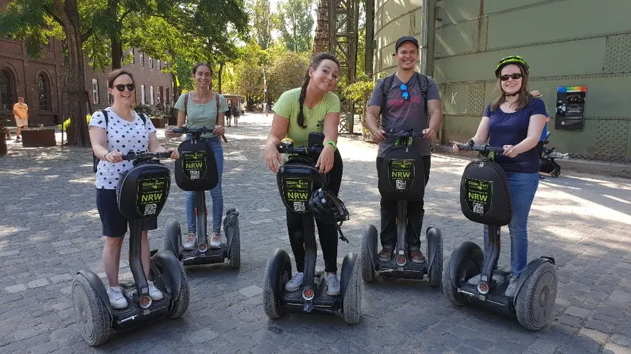 Five people on segways in urban area.