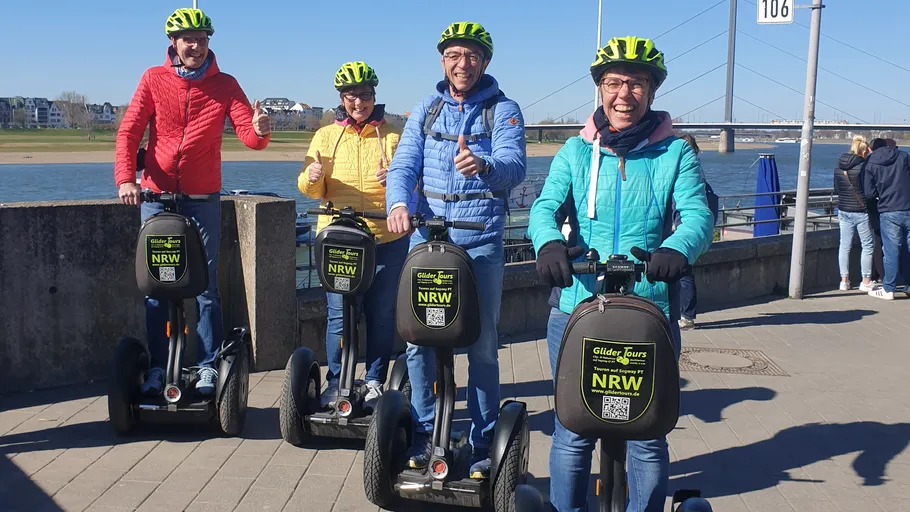 Four people on Segways near a river.