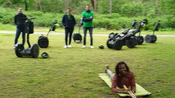 People with segways in a forest clearing.
